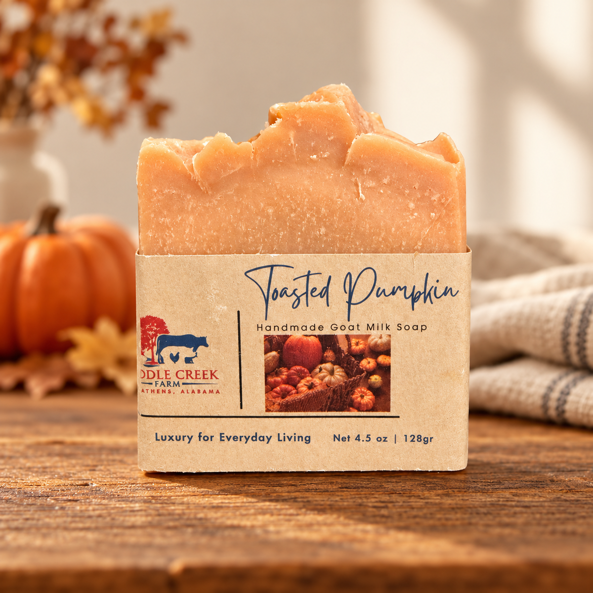 Toasted Pumpkin goat milk soap in kraft packaging on warm wood with autumn pumpkins and linen.